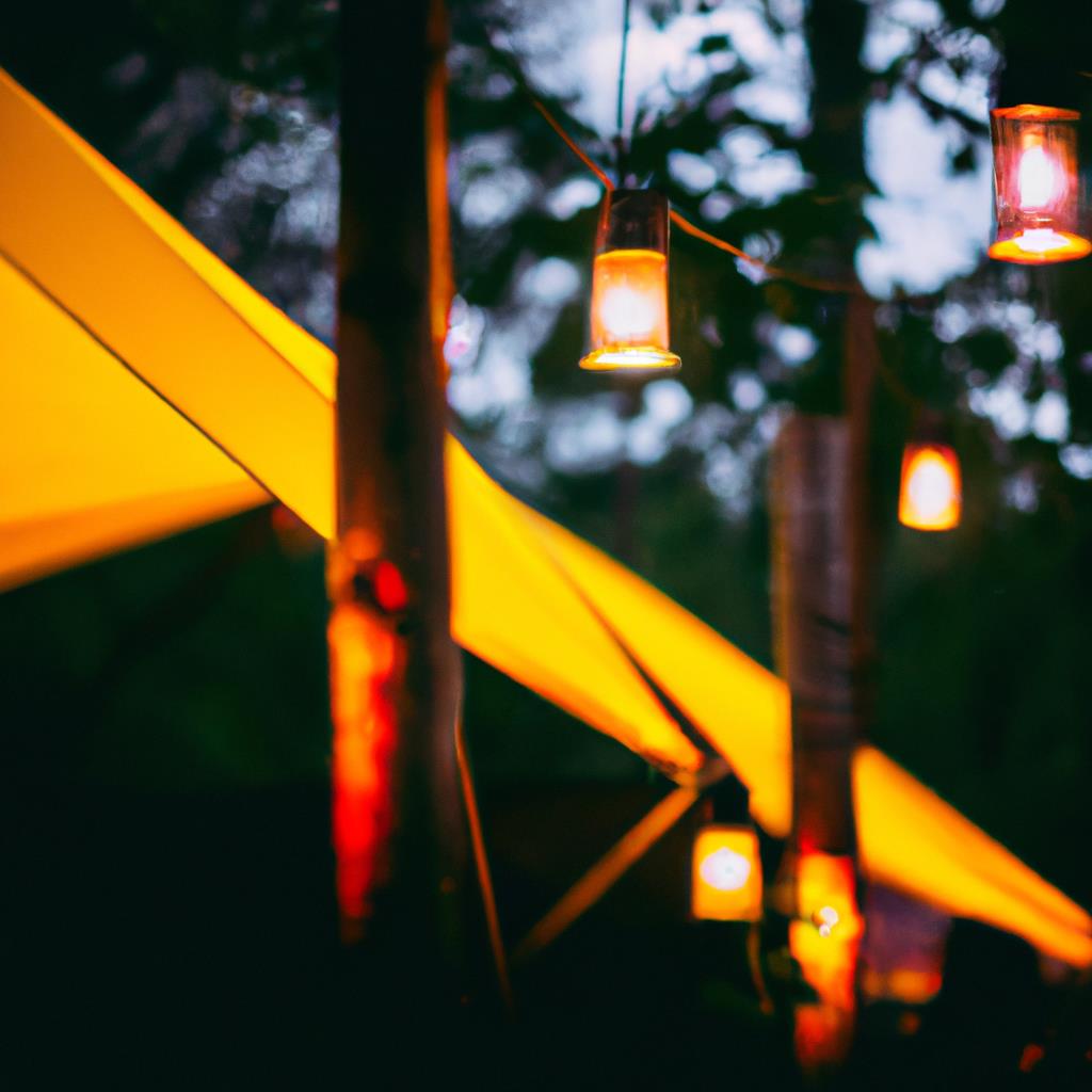 Two people sitting around a campfire at a tenting and camping site. A beautiful view of the starry night sky above. A tent pitched under tall trees. A peaceful and relaxing setting for a camping getaway.